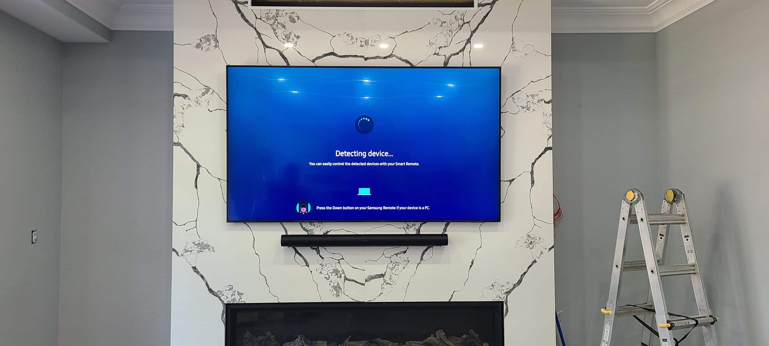 Professional 75-inch TV wall mounting on porcelain tile with soundbar in Woodbridge.