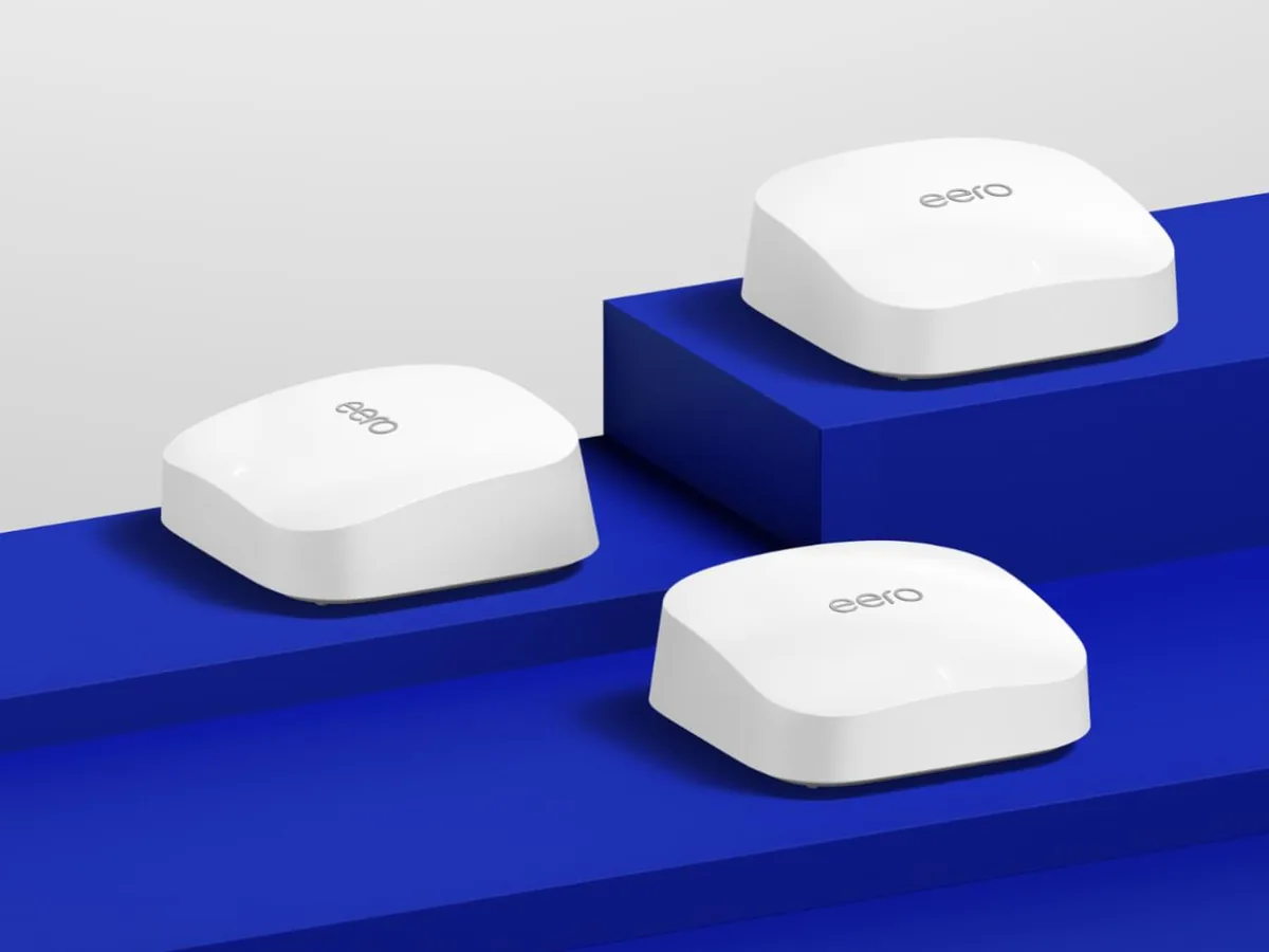 eero Pro 6E three-unit mesh Wi-Fi set on a blue studio backdrop