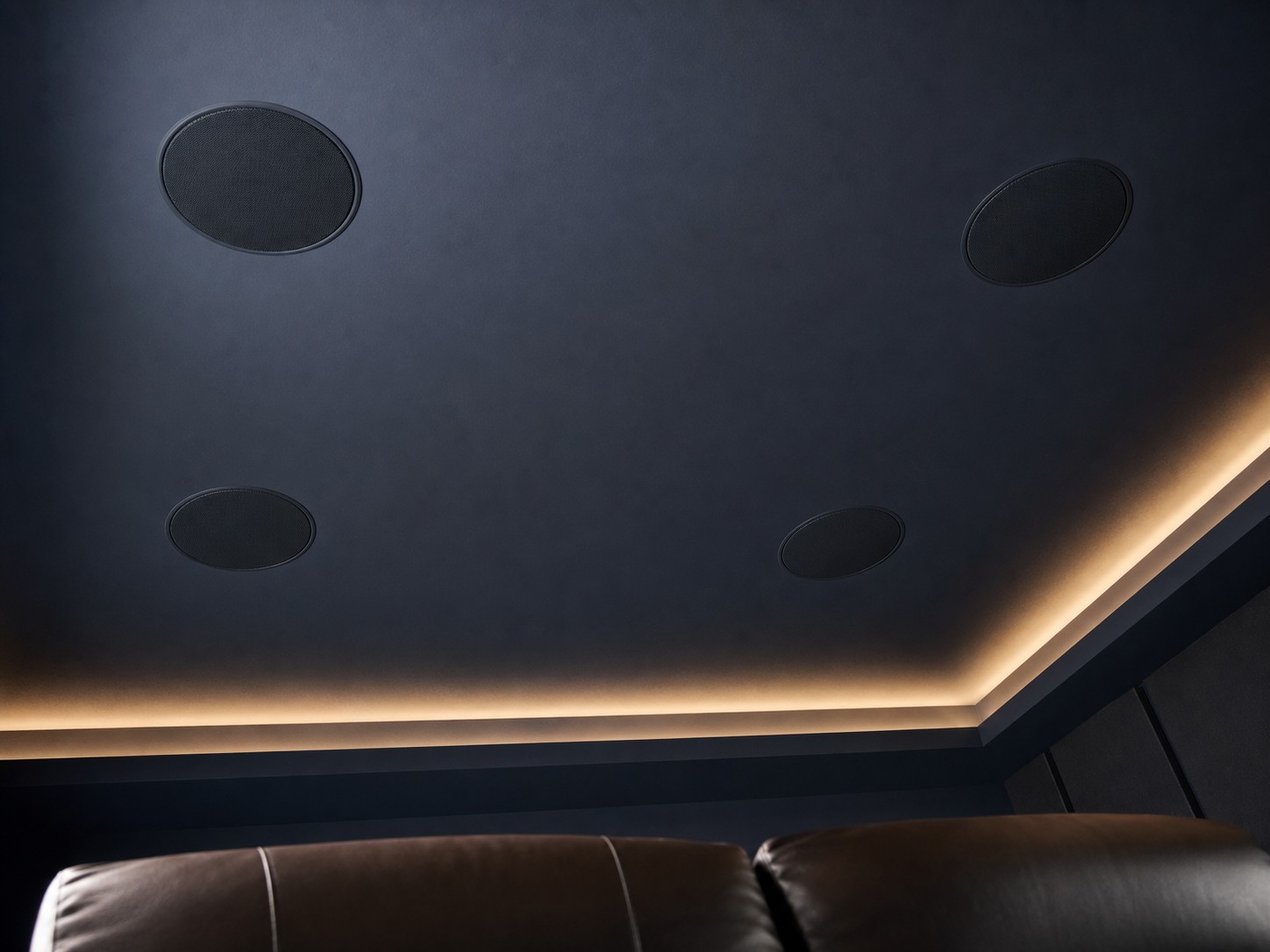Four flush in-ceiling Dolby Atmos height speakers laid out in a precise rectangular pattern in a finished home theatre ceiling