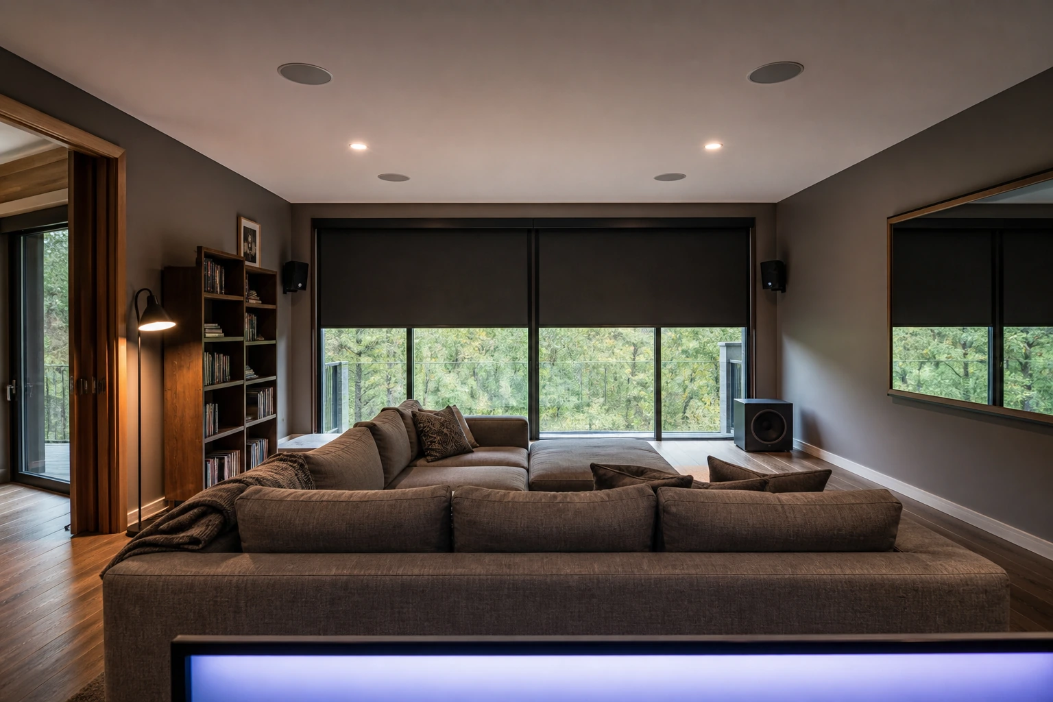 Walkout-basement Dolby Atmos room in a Sunnylea mid-century ranch, Etobicoke — blackout treatment over ravine-side sliding doors, 7.1.4 in-ceiling layout, 100-inch fixed-frame screen, sectional seating 12 feet back