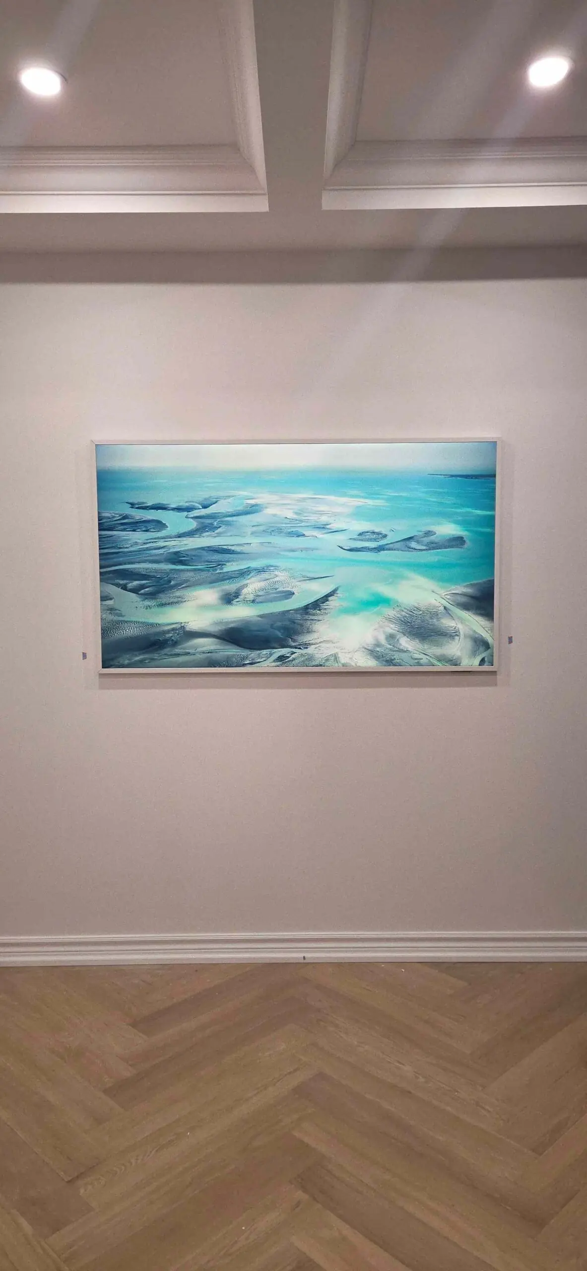 65-inch Samsung Frame TV with a custom white bezel displaying artwork on a wall