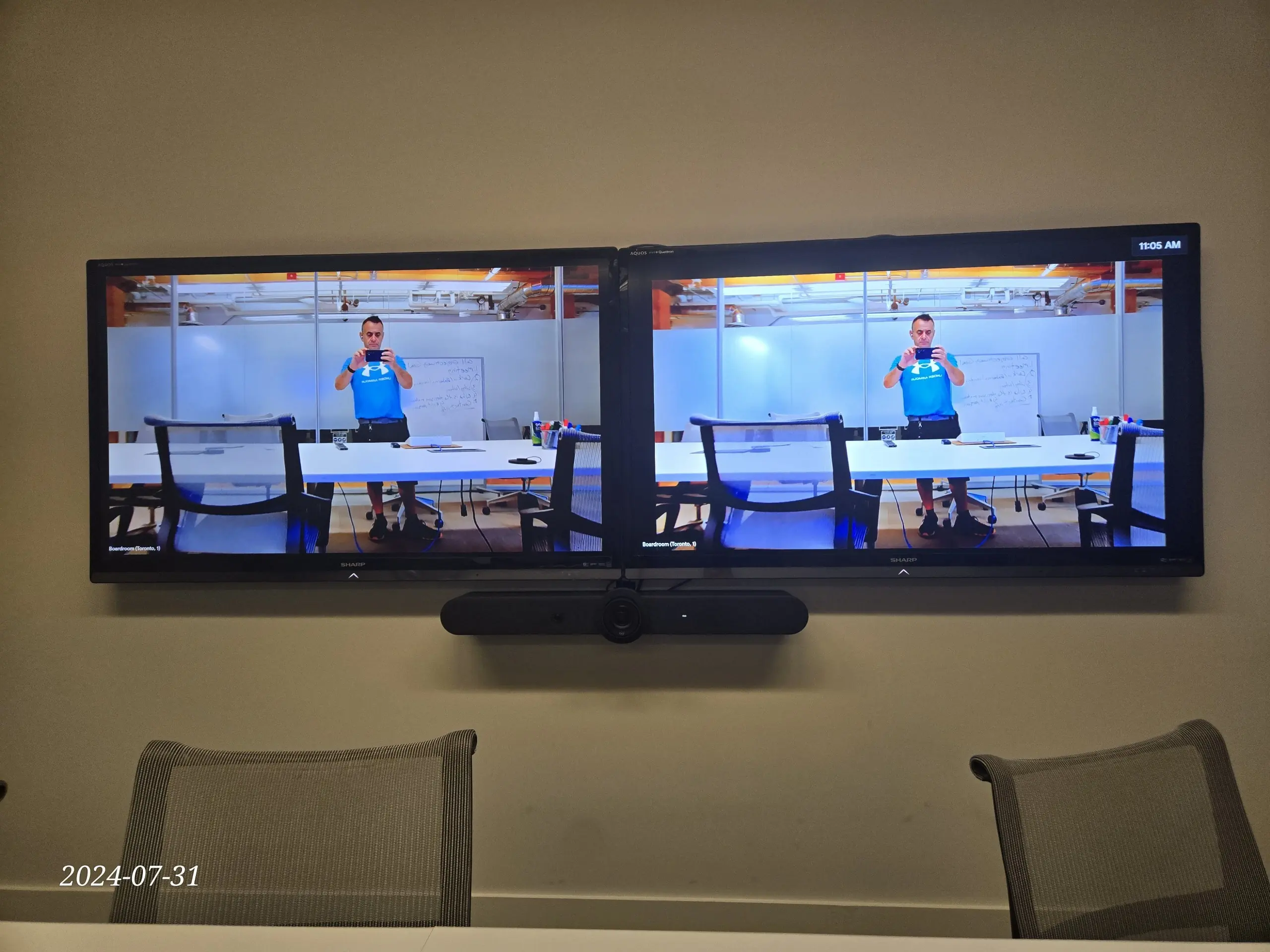 Dual-display video conference room with video bar installation
