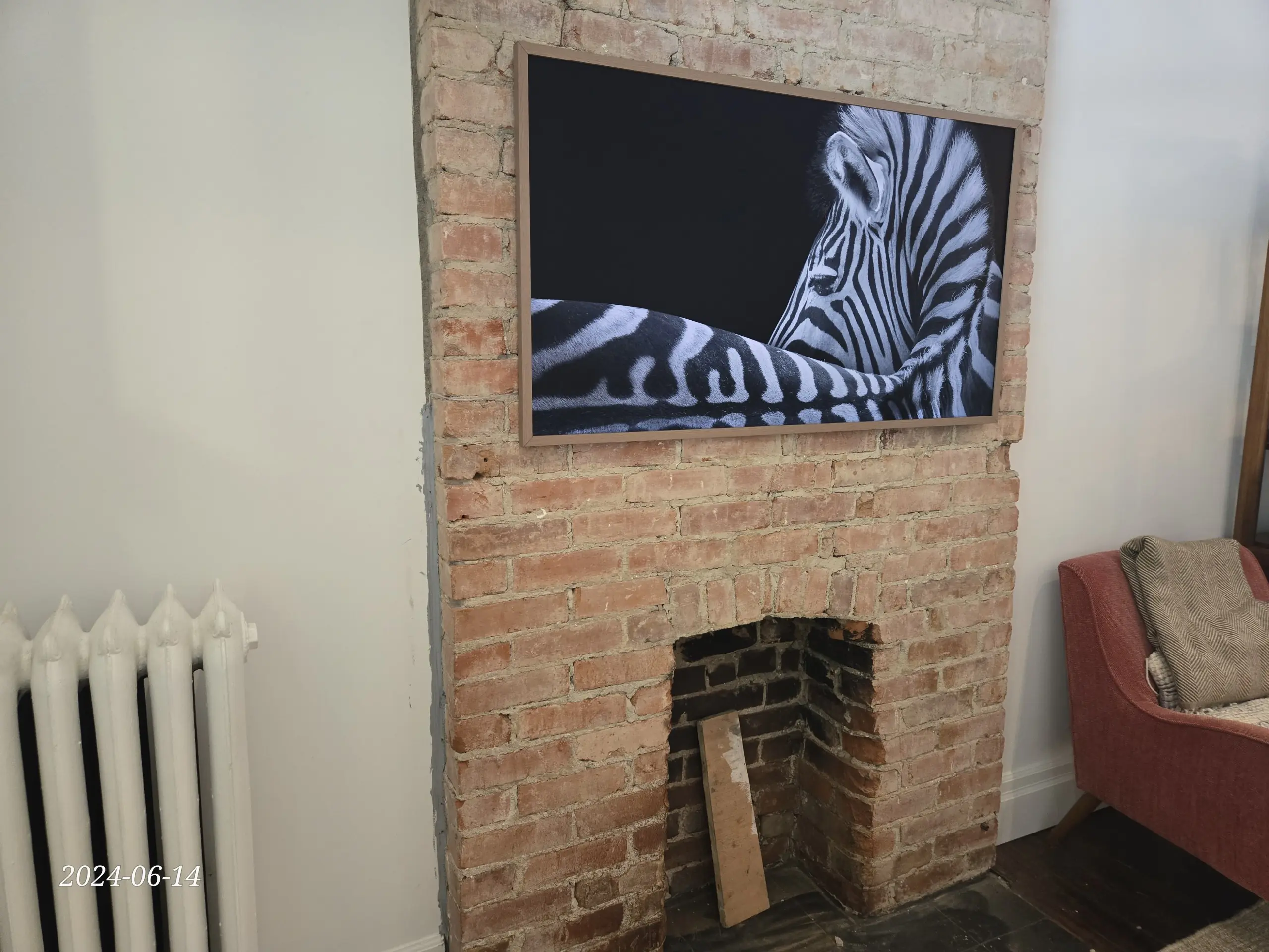 Samsung Frame TV mounted above a brick fireplace with clean cable concealment