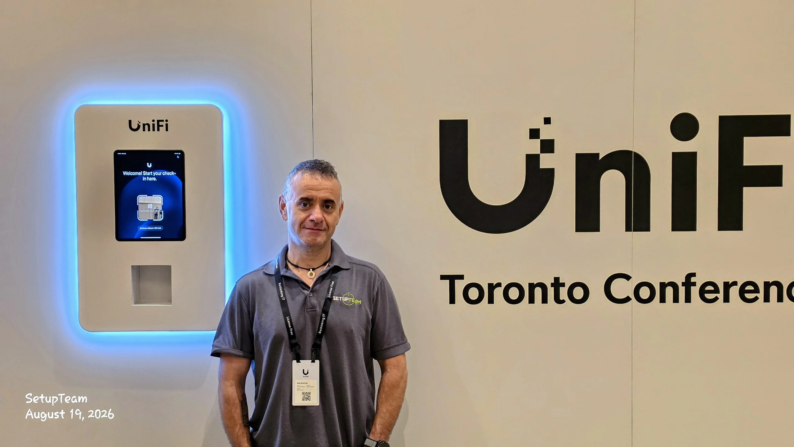 Alex Braiman of SetupTeam at the UniFi self-service check-in kiosk beside the UniFi Toronto Conference signage