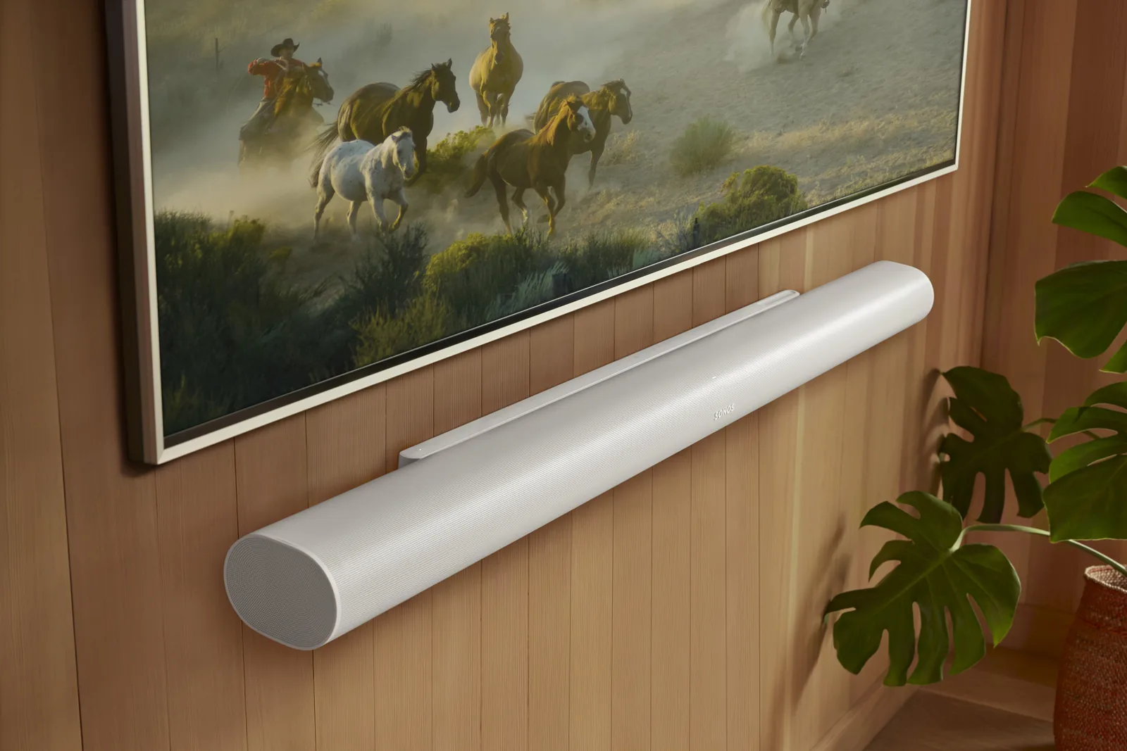 Close-up of a white Sonos Arc Ultra soundbar wall-mounted under a TV