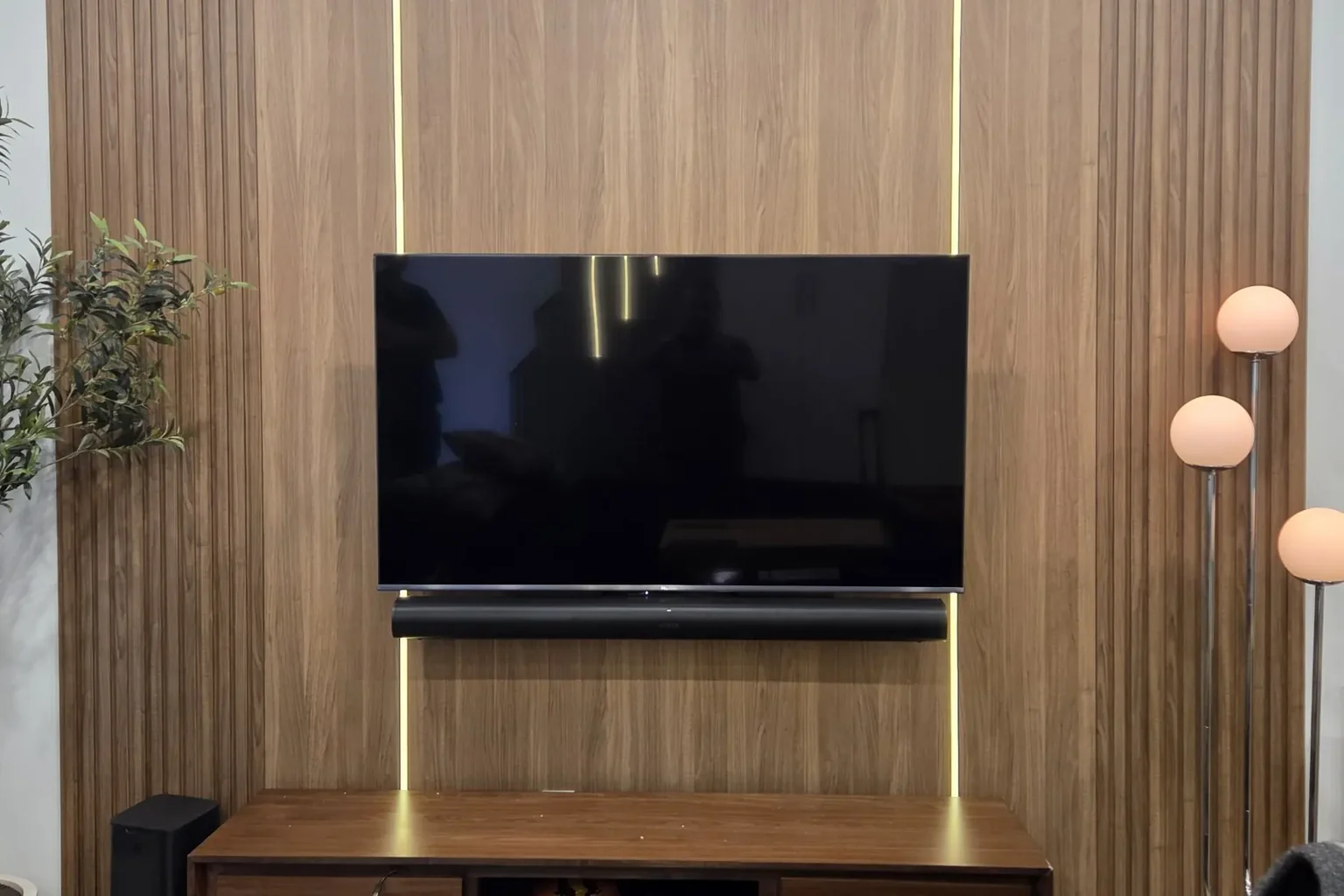 Sonos Arc soundbar wall-mounted below a TV with a hidden floating walnut console in a North York living room