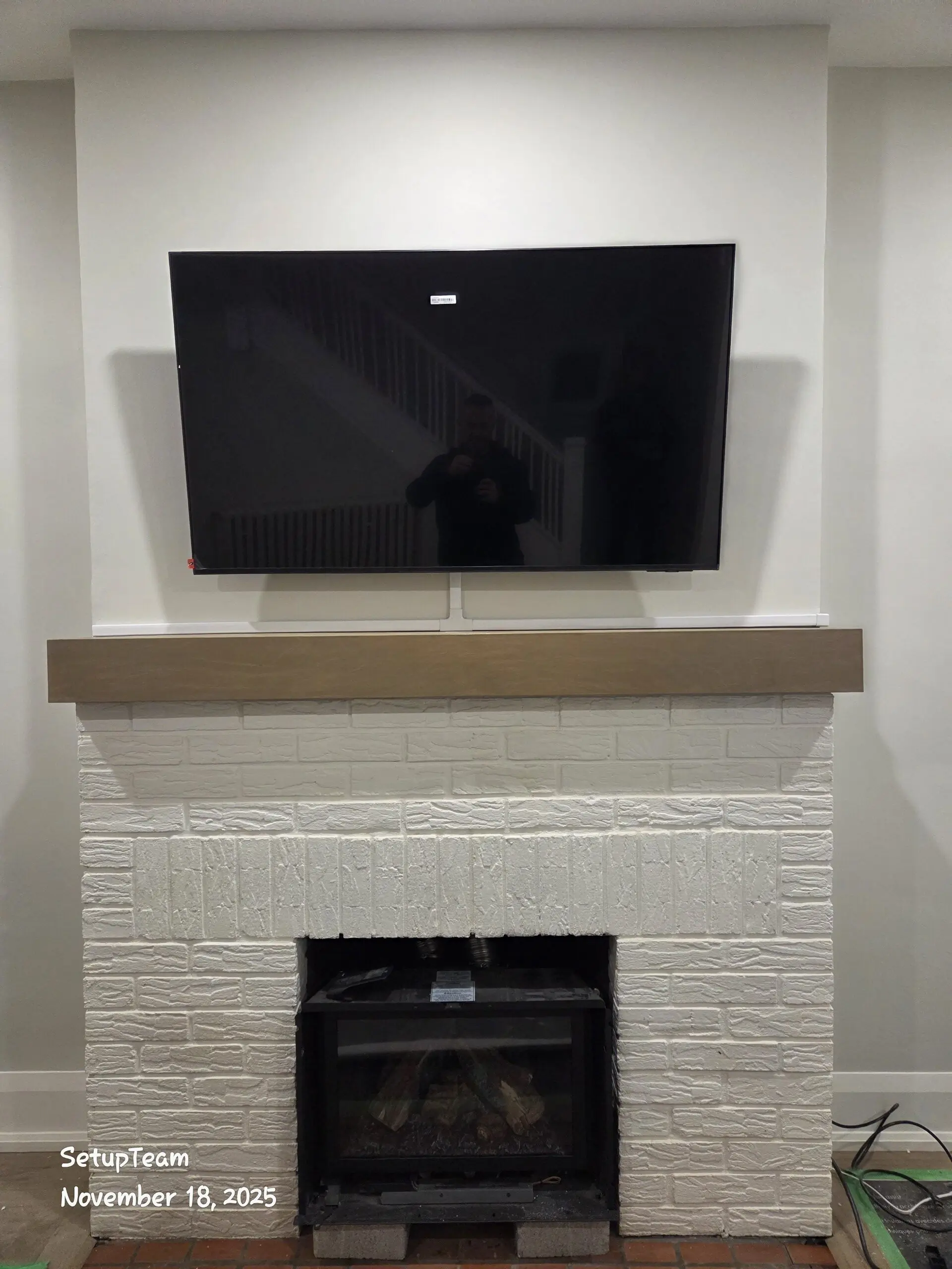 TV above fireplace, cables hidden behind trim cover