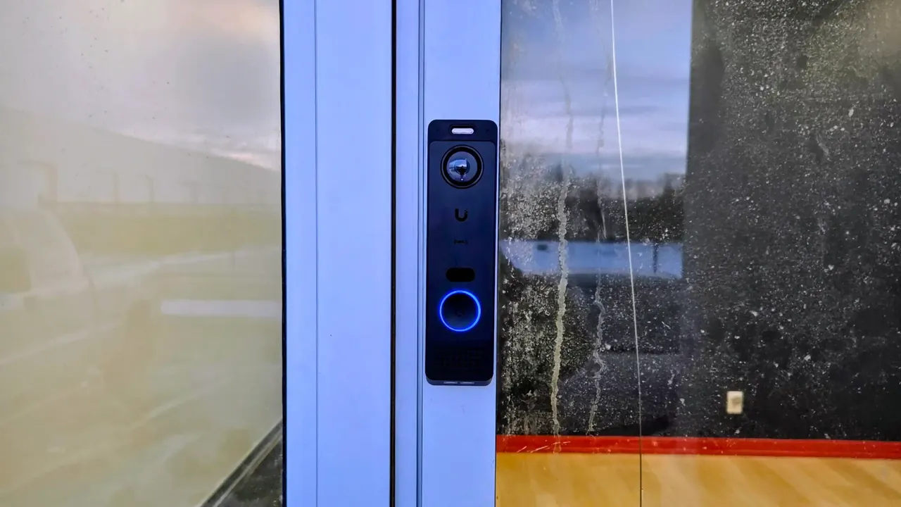 UniFi Access door reader mounted on the frame of a commercial glass door