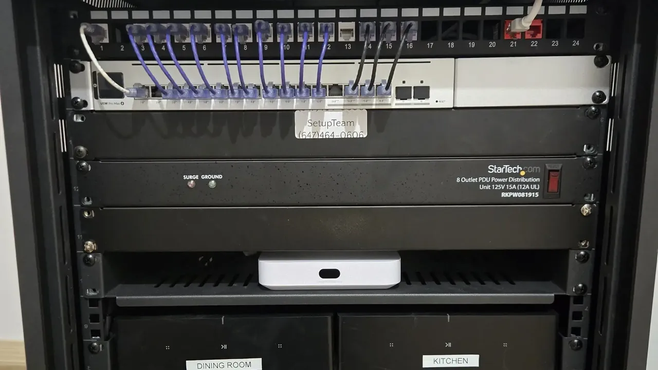 UniFi Cloud Gateway on a rack shelf below a patch panel and switch in a home network rack