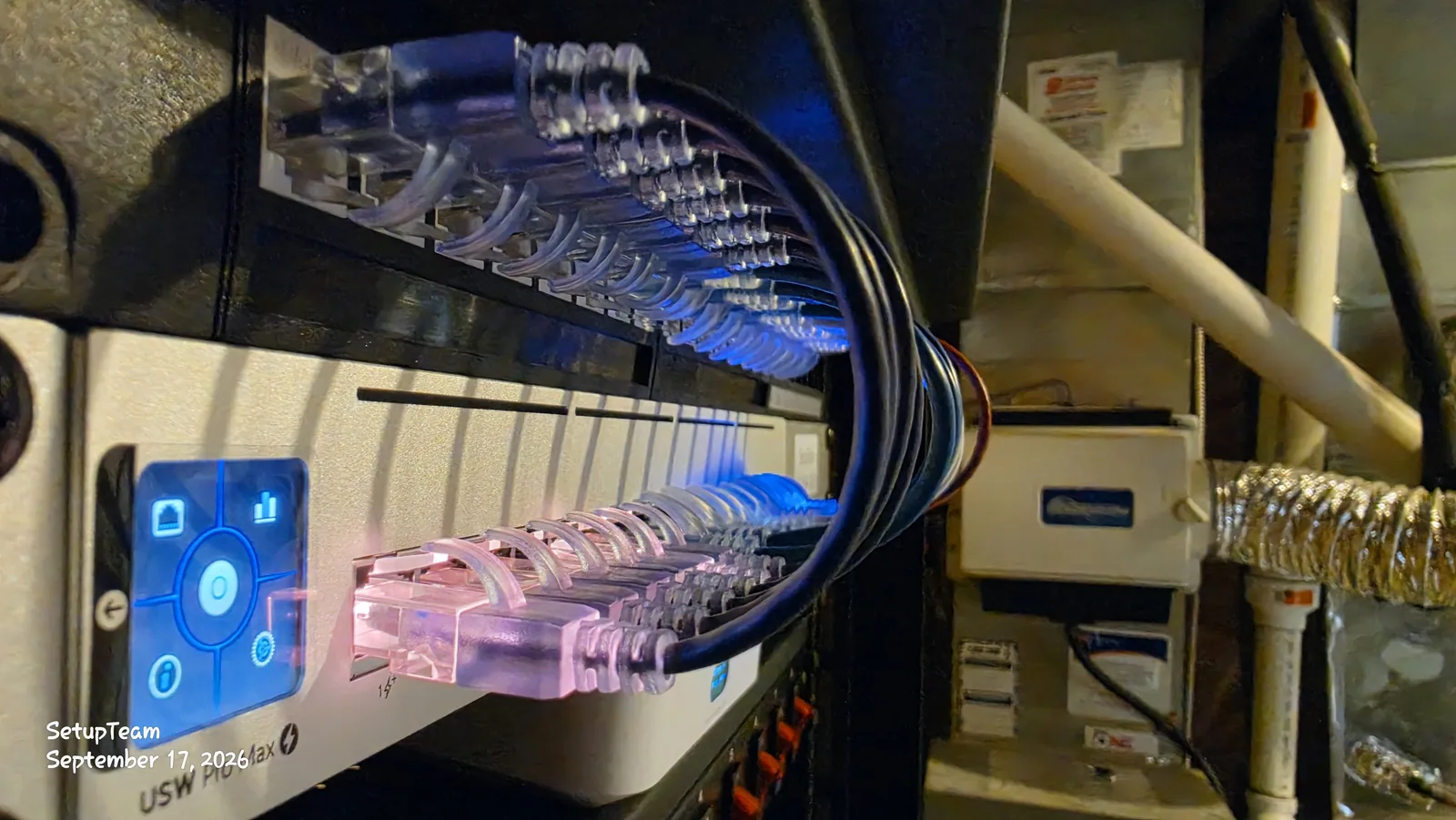 Short patch cables dressed into a UniFi USW Pro Max switch in a basement network rack