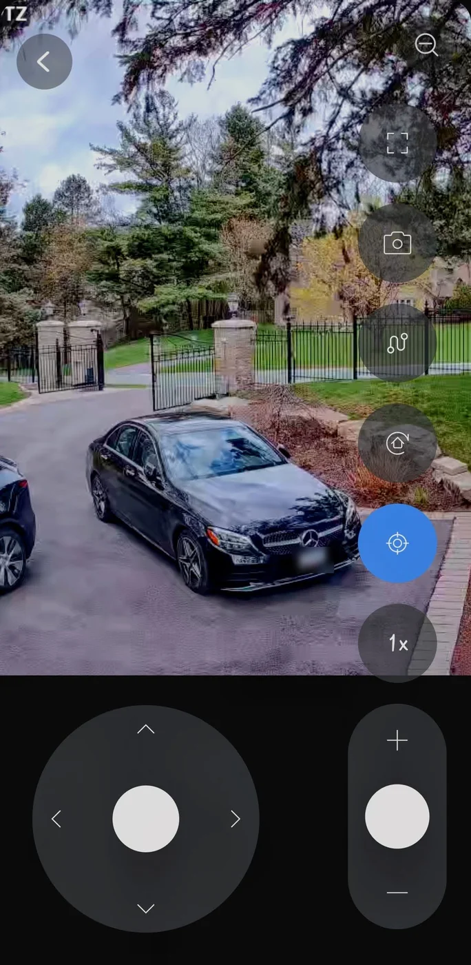UniFi Protect mobile app showing a live PTZ camera view of a gated driveway with on-screen pan, tilt and zoom controls