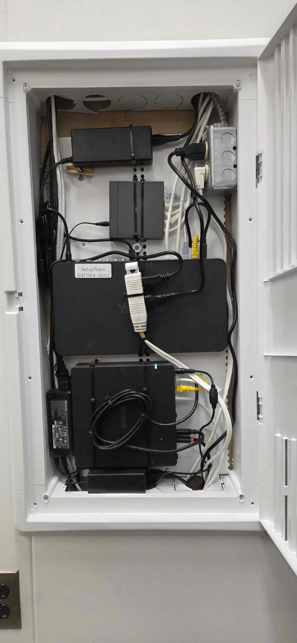 Yealink video conferencing equipment cabinet with managed switch, structured patching, audio DSP, UPS, and tidy cable management for a corporate conference-room AV deployment
