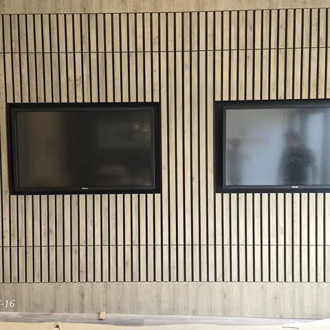Dual commercial display mounting installation integrated into a custom slat wall feature for a sales center completed by SetupTeam in Toronto.
