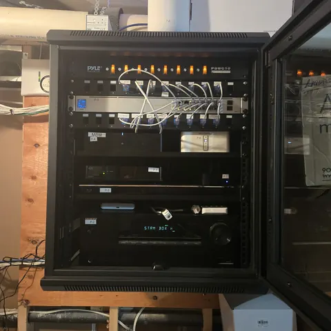 Professional network rack installation featuring UniFi networking, Sonos audio distribution, security camera integration, and home theater equipment in Vaughan.