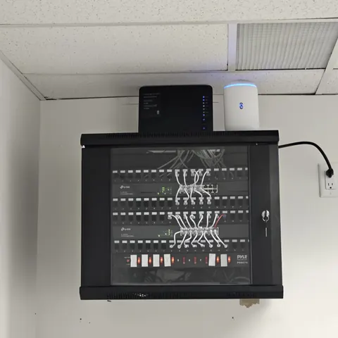 Commercial network rack installation with UniFi distribution system, VLAN network configuration, and security camera integration in Toronto.