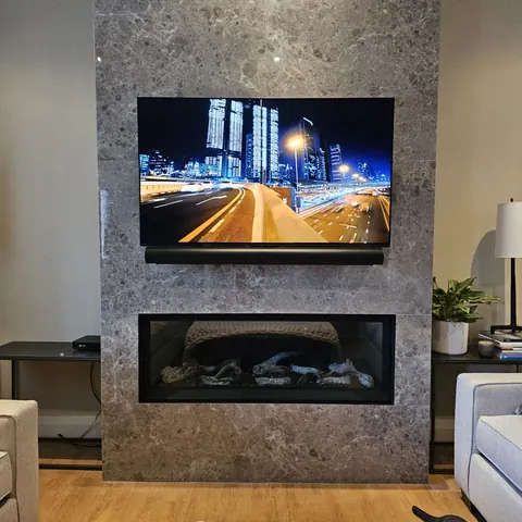 TV wall mounting on a porcelain fireplace feature wall with Sonos Arc Ultra installation completed by SetupTeam in Vaughan.