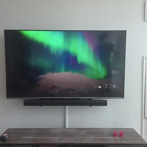 Professional TV wall mounting with soundbar installation and surface cable concealment for a modern condo setup in Toronto.