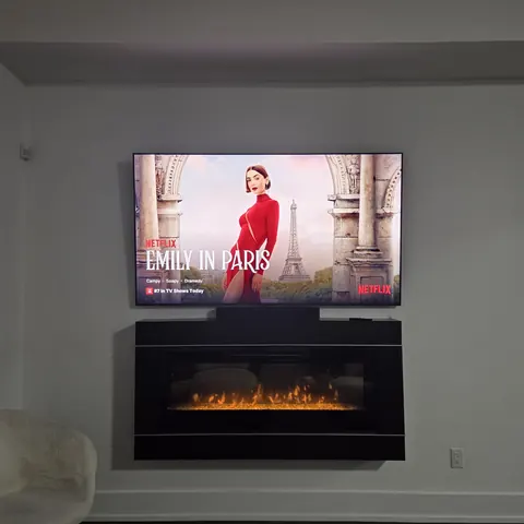Professional TV wall mounting installation above a modern electric fireplace in Mississauga.