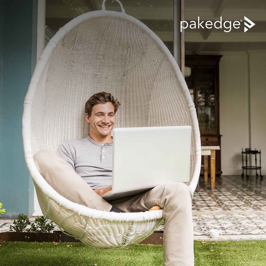 Man working on a laptop in a hanging chair on an backyard patio with strong Wi-Fi coverage