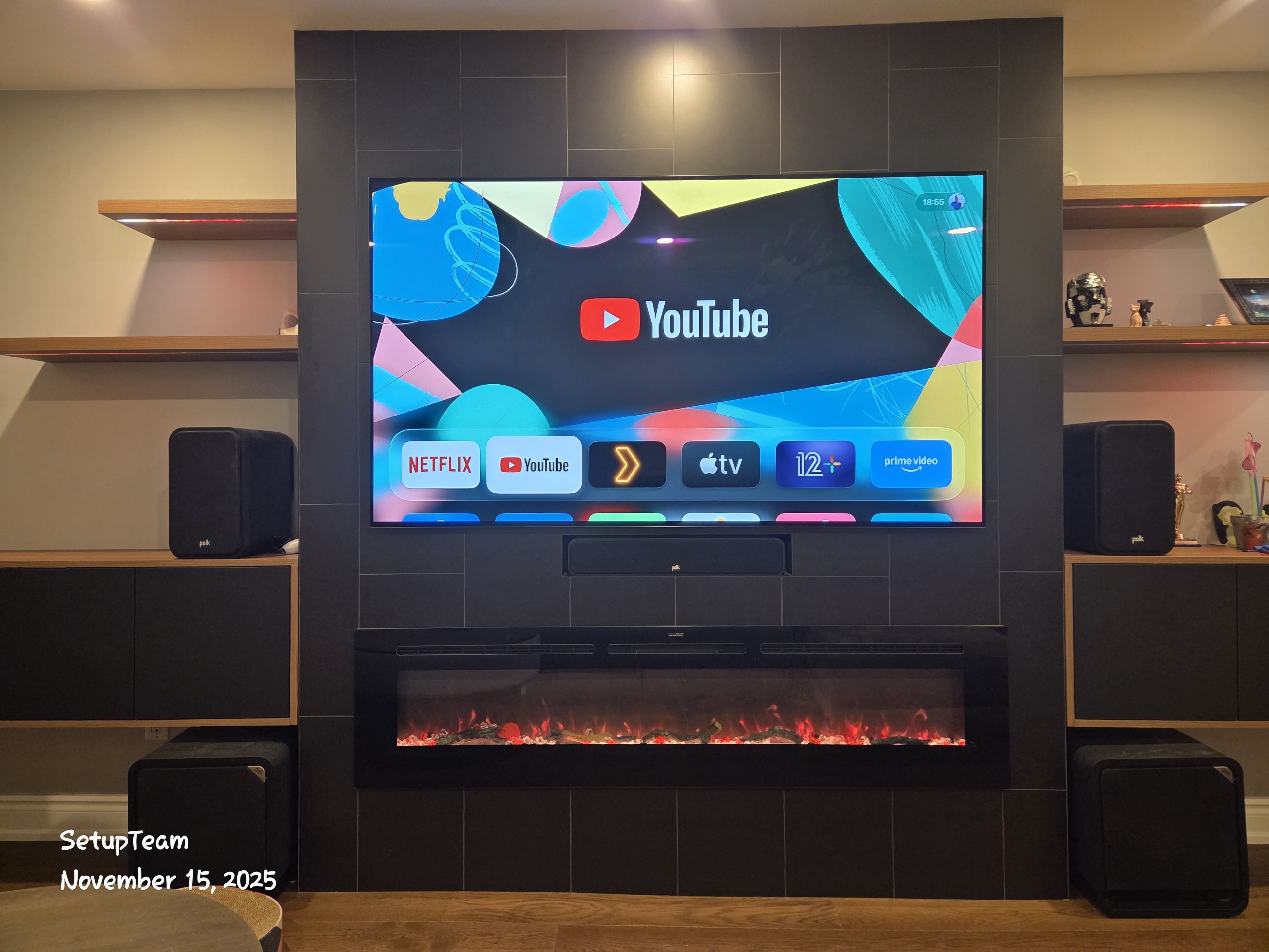 Custom home theater installation with surround sound and large display above fireplace