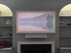 Samsung Frame TV wall-mounted above a fireplace with a Sonos Beam soundbar installed.