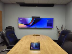 Dual-screen Zoom Rooms video conferencing setup with two wall-mounted displays in an office meeting room