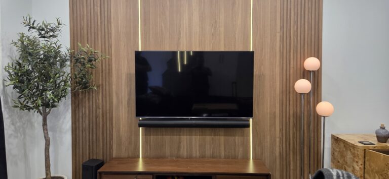 Wall-mounted TV on a wood feature wall with a soundbar installed below