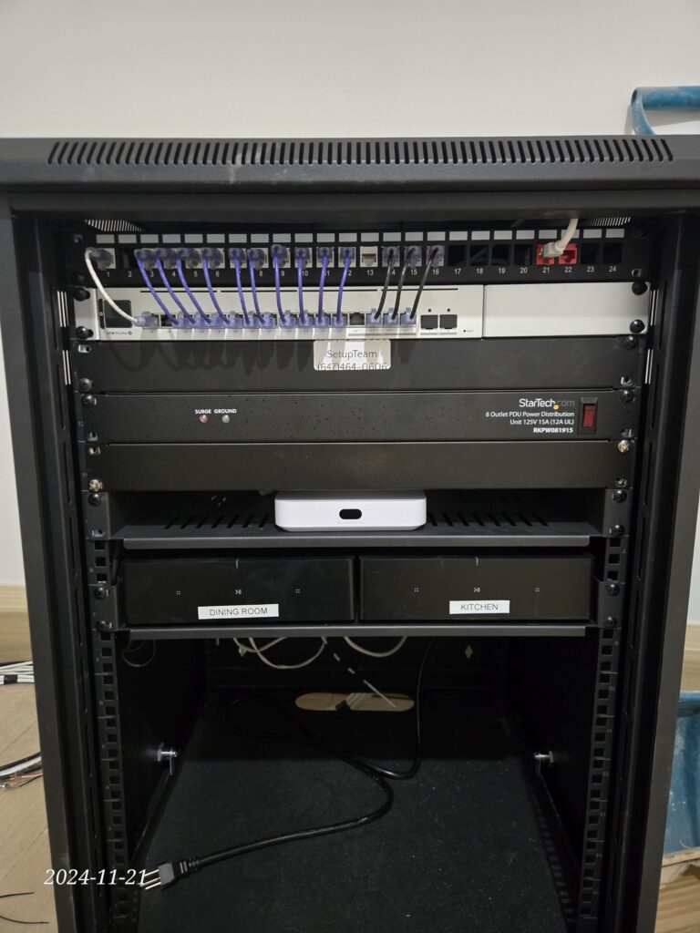 UniFi network rack with router, switches, and Sonos amps for home theater audio distribution and Wi-Fi