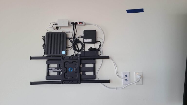 Logitech Rally Plus video conferencing equipment with in-wall wire concealment behind the TV for a clean install