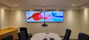 Dual-screen Zoom Room setup in a meeting room with two wall-mounted displays