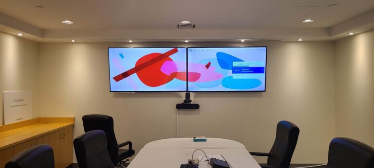 Dual-screen Zoom Room setup in a meeting room with two wall-mounted displays