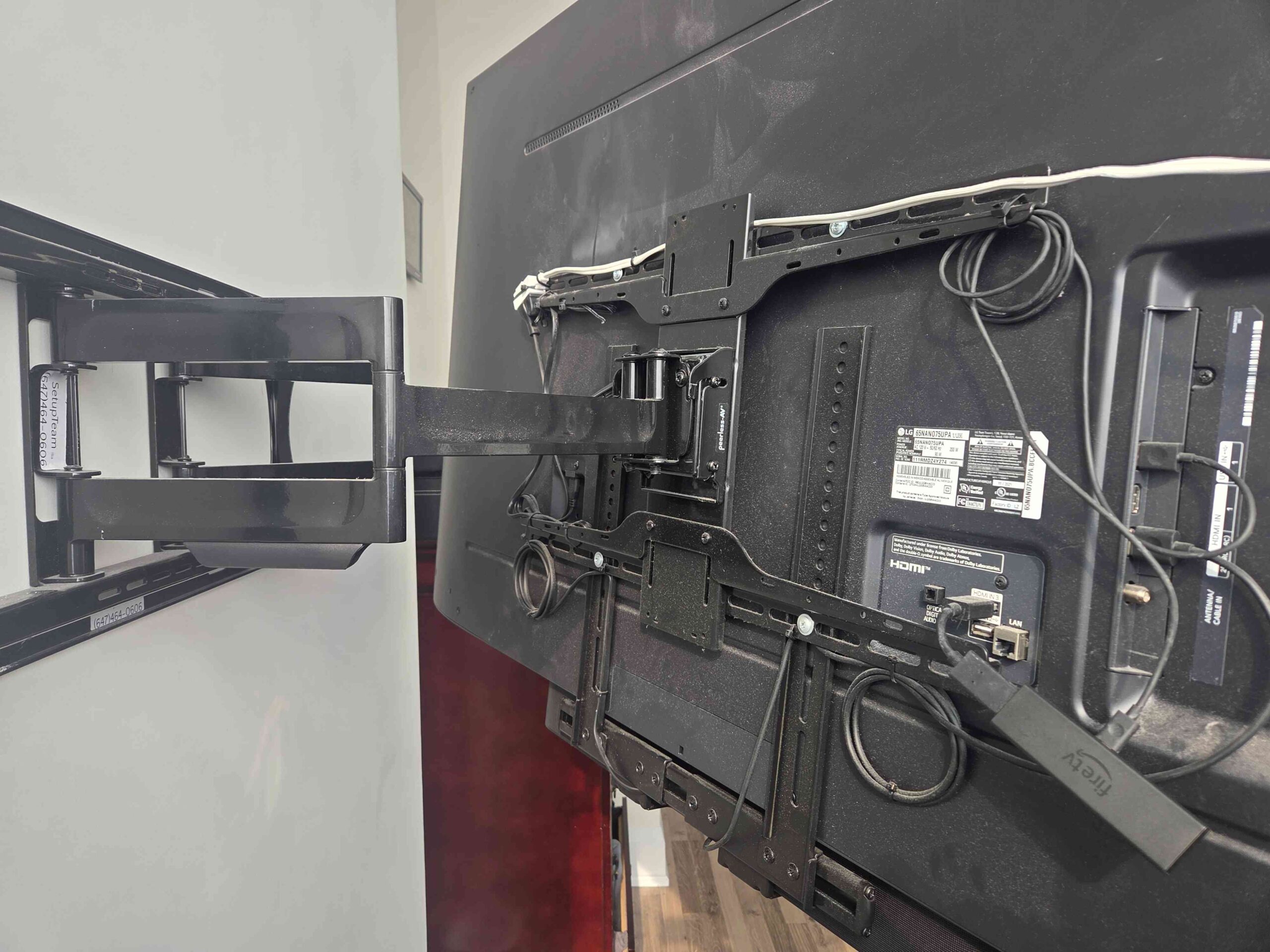 Professional wire management behind a wall-mounted TV with neatly secured cables and articulated mount