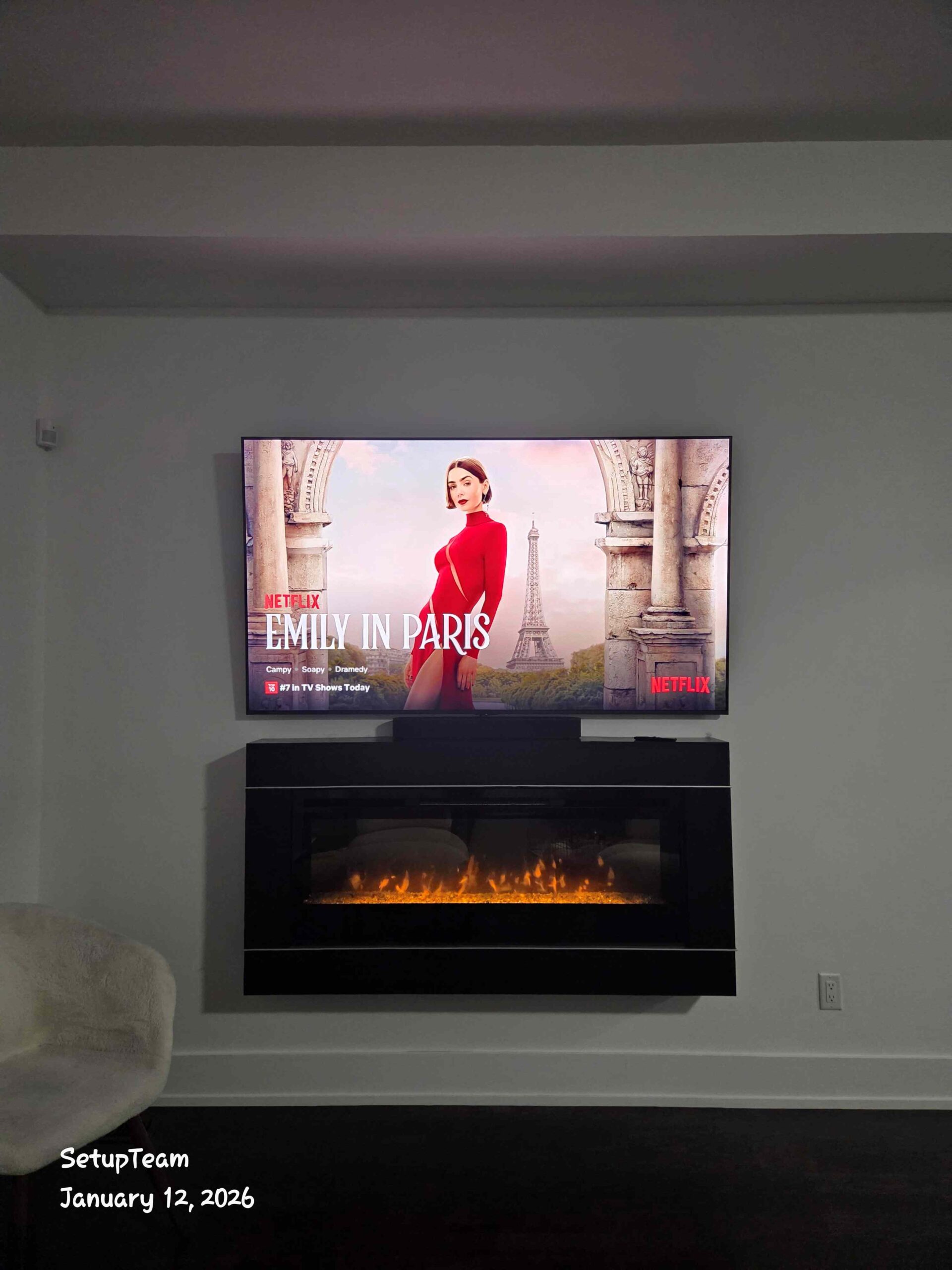TV mounted above a fireplace with a Sonos Beam soundbar below in a living room