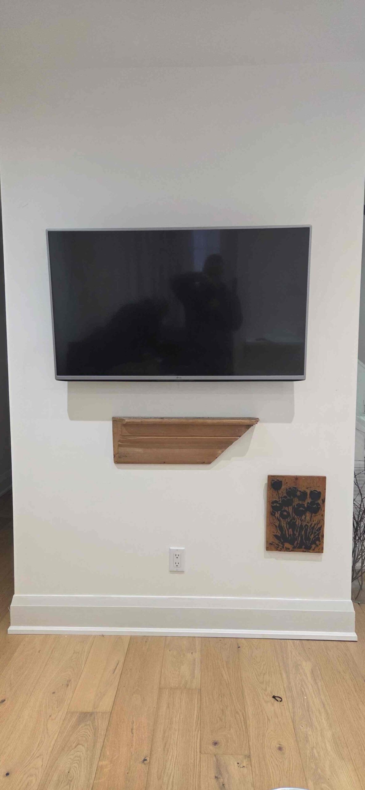 TV wall mounted above a floating media shelf in a finished interior space